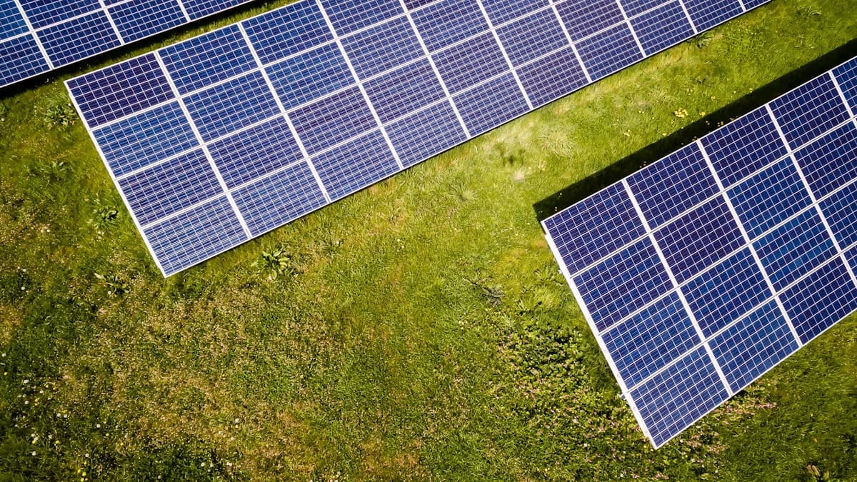 Vue aérienne de panneaux photovoltaïques installés au sol dans une prairie, prise du dessus (drone).